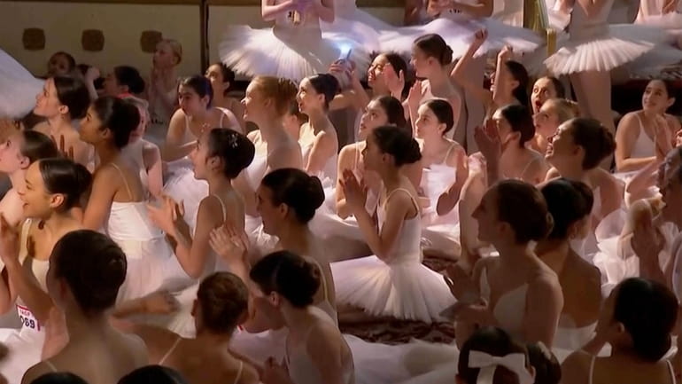 This image taken from video shows dozens of young dancers...
