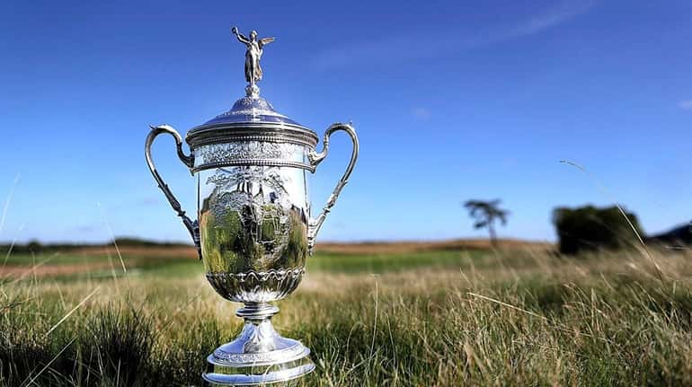 The U.S. Open trophy sits in the fescue beside the...