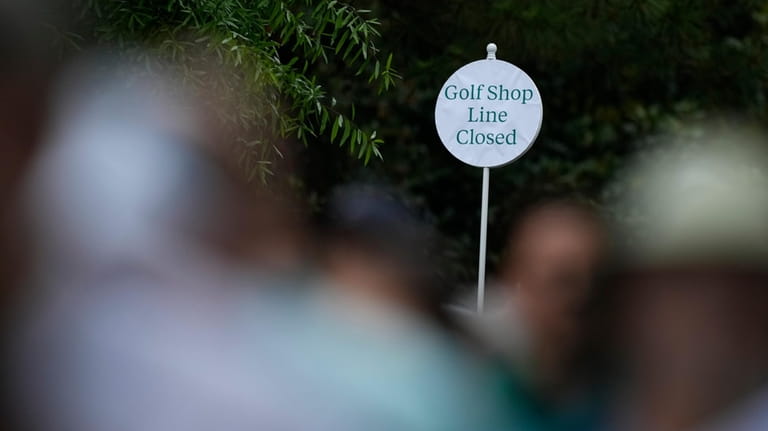 A sign is posted closing the golf shop line during...
