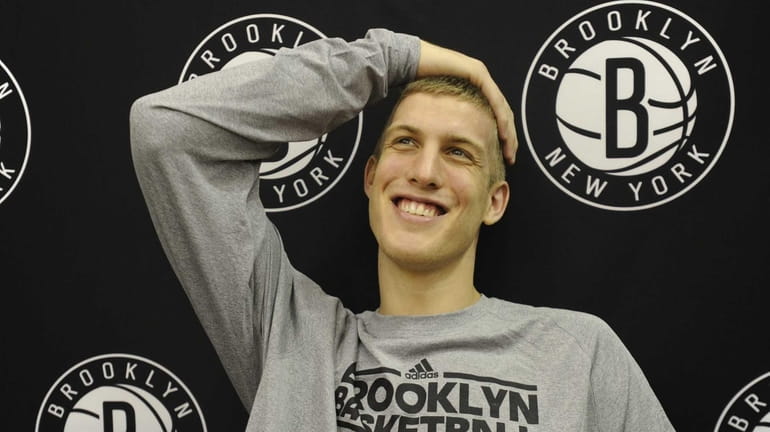 Mason Plumlee talks with the media following practice at the...