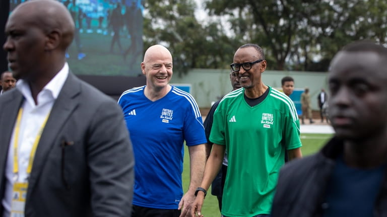 FIFA president Gianni Infantino, centre left, walks with Rwanda's President...