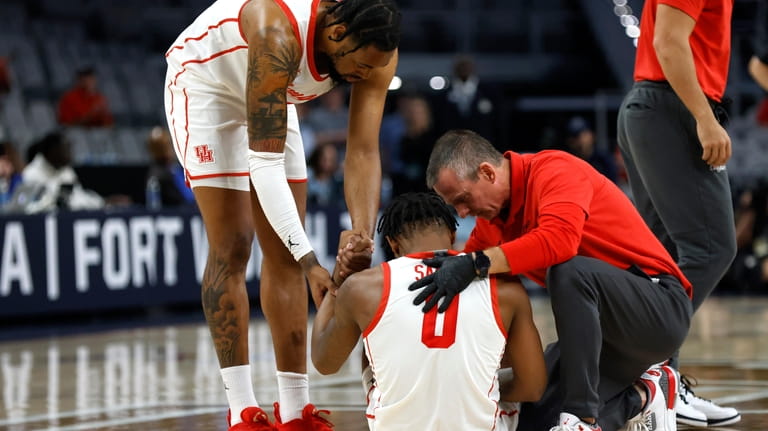 Houston forward Jarace Walker (25) and team staff attend to...