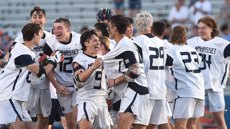 Manhasset boys lacrosse teammates celebrate after their 12-7 win over...