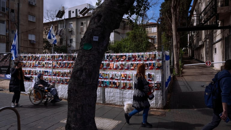 A fence displays photographs of Israelis who are being held...