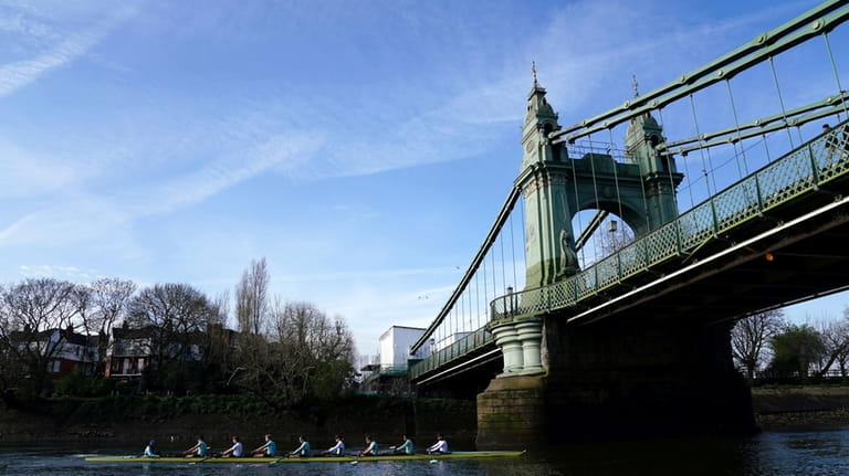 The Cambridge men's team pass under Hammersmith Bridge during a...