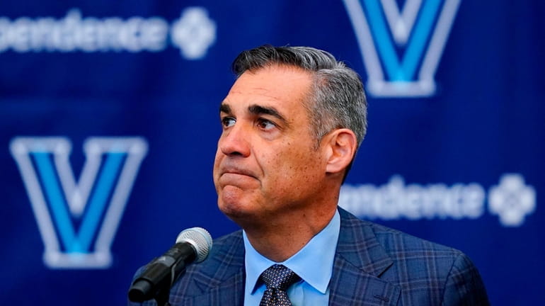 Jay Wright grimaces while speaking at a news conference about...