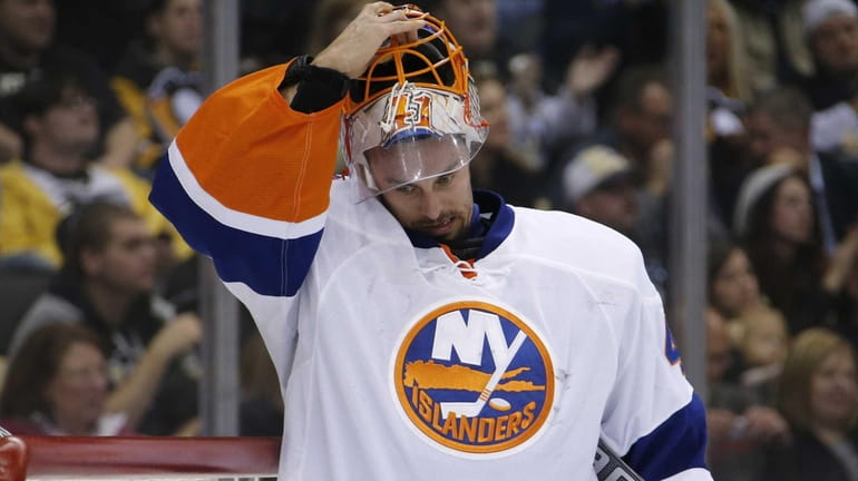 Islanders goalie Jaroslav Halak removes his mask after allowing a...