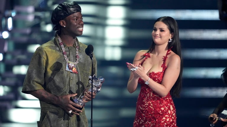 FILE- Rema, left, and Selena Gomez accept the award for...