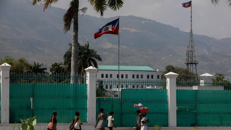 People walk past the National Palace in Port-au-Prince, Haiti, Monday,...