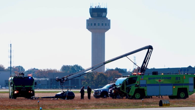 Airport emergency crews at the scene of a helicopter that...