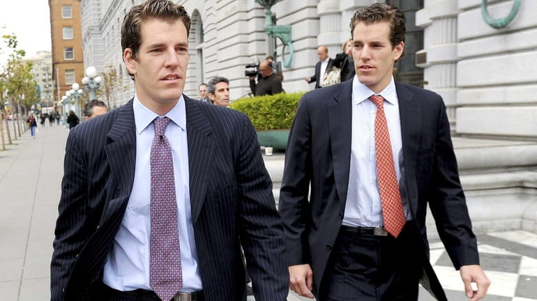 Tyler Winklevoss, left, and his twin brother Cameron, leave a...