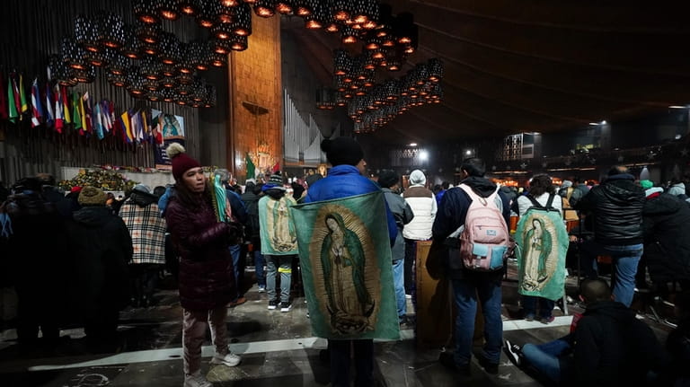 Pilgrims stand inside the Basilica of Guadalupe on her feast...
