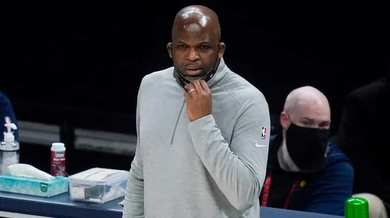 Hawks coach Nate McMillan watches during the first half of...