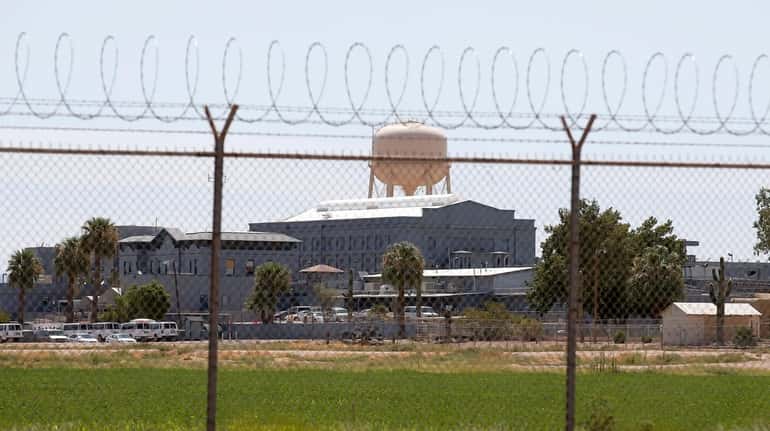 A fence surrounds the state prison in Florence, Ariz., where...