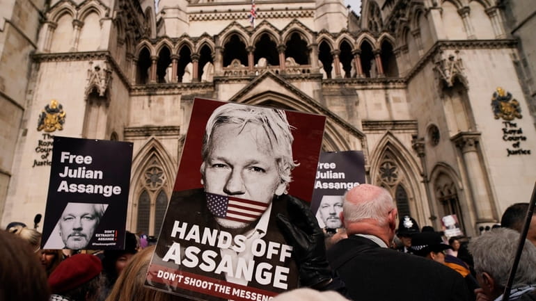 A demonstrator holds a placard, after Stella Assange, wife of...