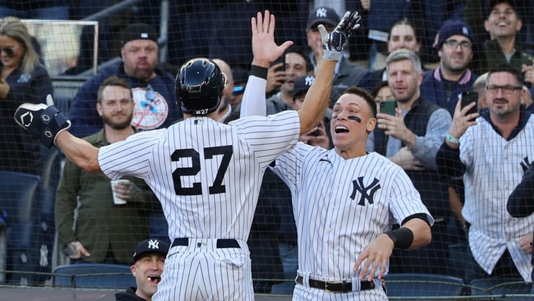 Yankees designated hitter Giancarlo Stanton (27) celebrates with Aaron Judge during...