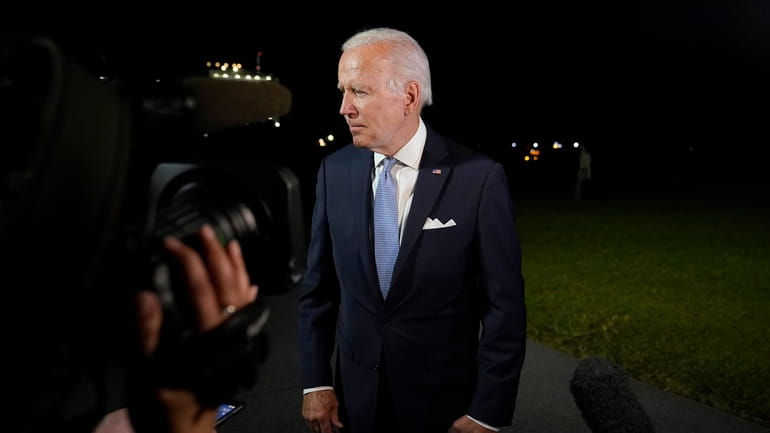 President Joe Biden stops to talk with reporters on the...