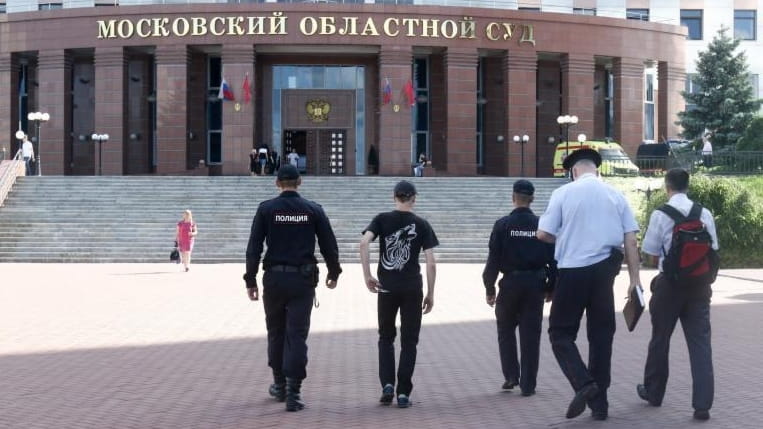 Police officers walk toward to the main entrance of Moscow...