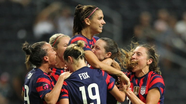 United States' Alex Morgan, top, is congratulated after scoring her...