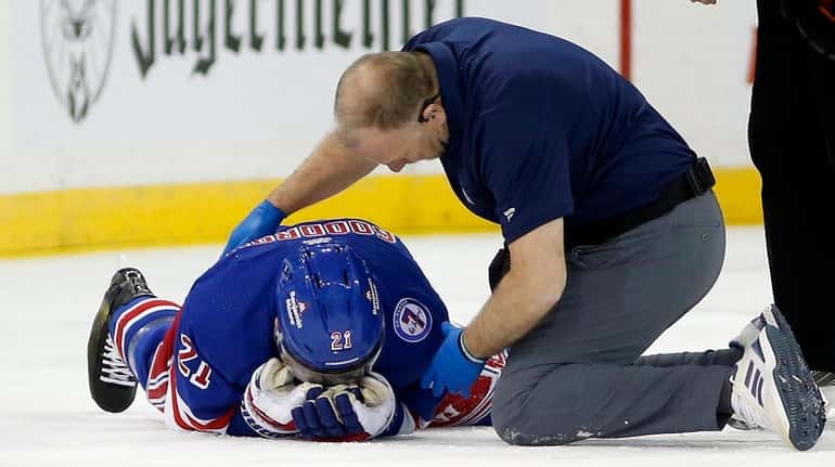 Barclay Goodrow #21 of the Rangers is tended to during...
