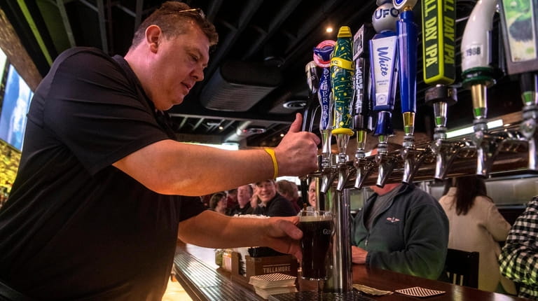 A bartender pours a beer at The Irish Poet in...