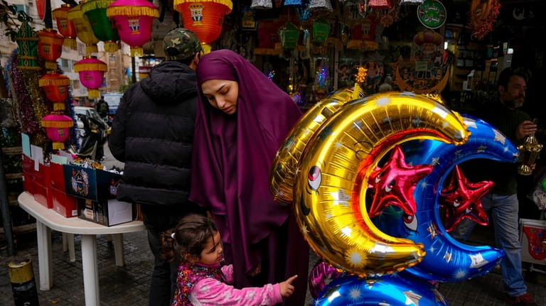 People shop for decorations for the Muslim holy month of...