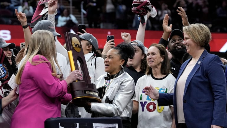 South Carolina head coach Dawn Staley, center, celebrates with the...
