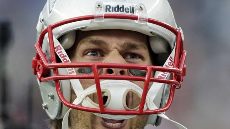 New England Patriots quarterback Tom Brady yells as he runs...
