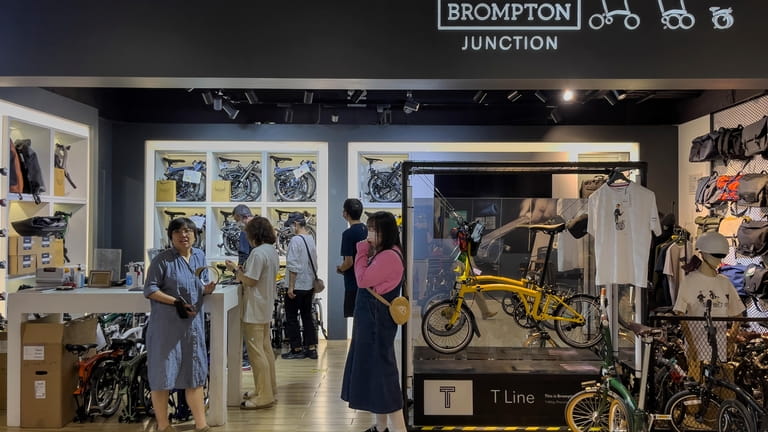 People shop at a folding bicycle retailer shop in Brompton...