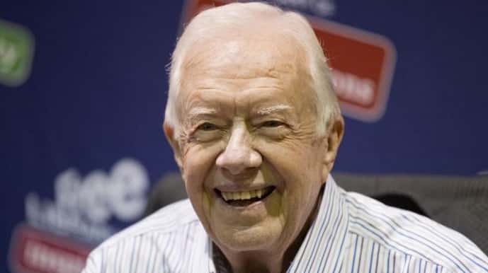 Former President Jimmy Carter poses for photographs at an event...