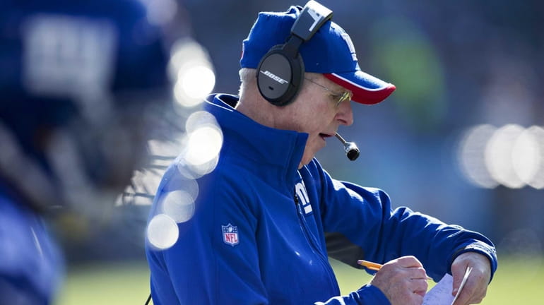 Giants head coach Tom Coughlin reviews a play on the...