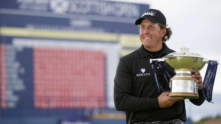 Phil Mickelson poses with the trophy after winning the Scottish...