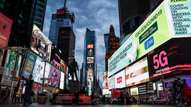 Screens lit up a sparsely populated Times Square in Manhattan after...