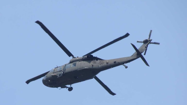 A Black Hawk helicopter flies above Ocean Parkway. (April 18,...