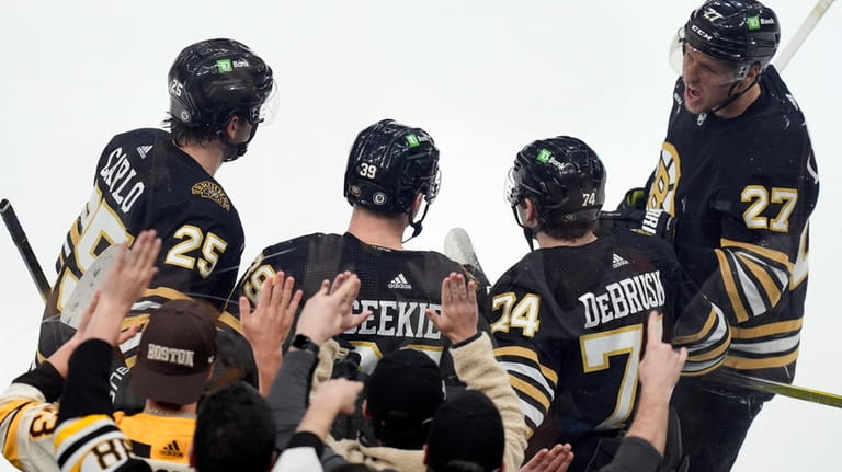 Boston Bruins' Morgan Geekie celebrates his goal with Brandon Carlo...