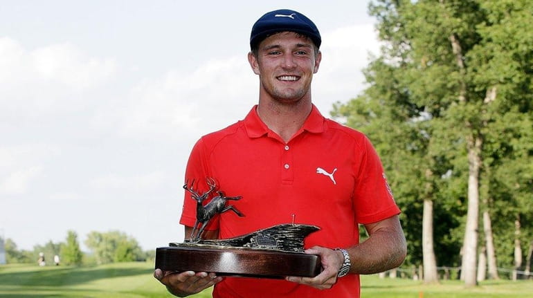 Bryson DeChambeau poses with the championship trophy following the final...