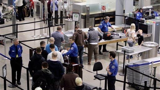 Airline passengers line up at the TSA security check at...