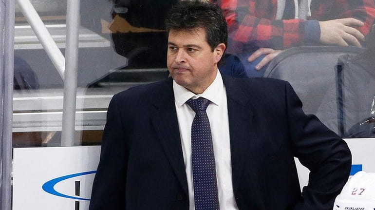 New York Islanders head coach Jack Capuano stands behind his...