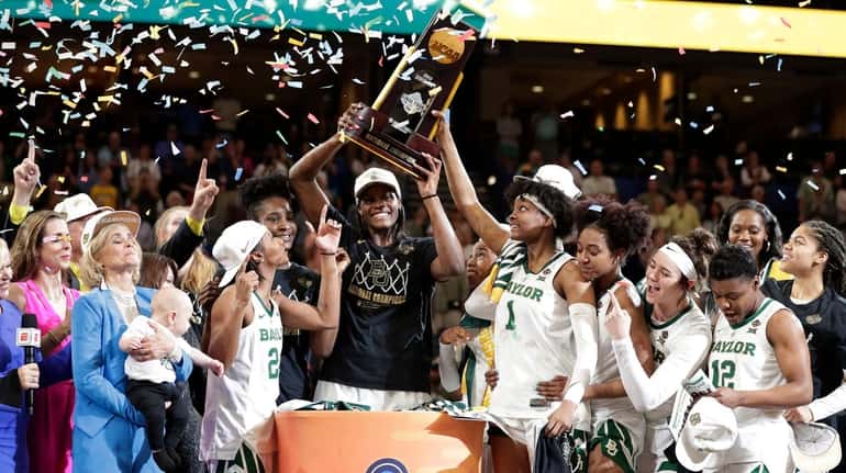 The Baylor team raises the championship trophy after defeating Notre...