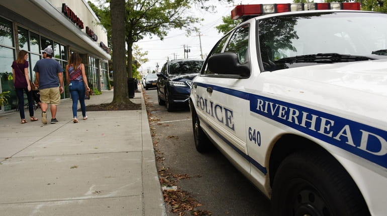 A Riverhead Town Police car is parked on East Main Street...