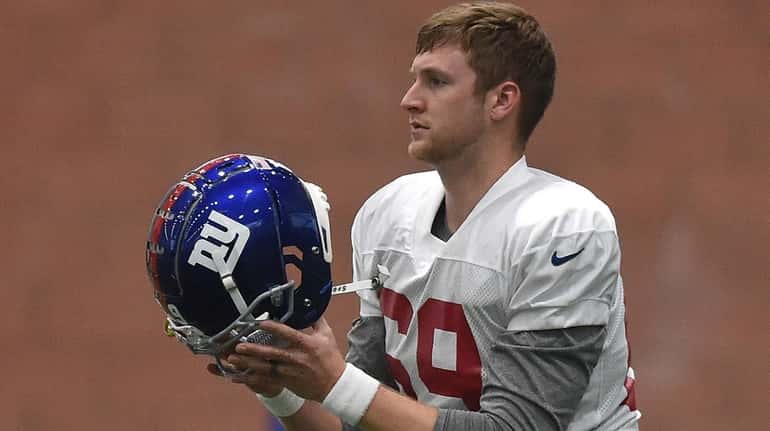 Giants long snapper Colin Holba puts on his helmet during the...