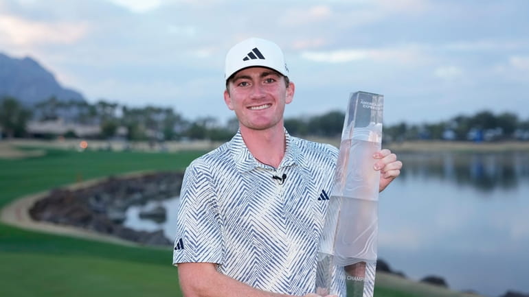 Nick Dunlap holds the trophy after winning the American Express...