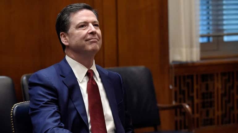 FBI Director James Comey waits for the start of a...
