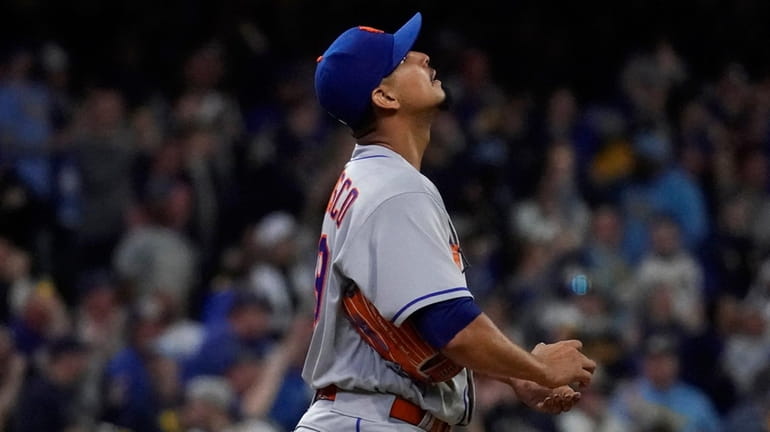 The Mets' Carlos Carrasco reacts after giving up a two-run...
