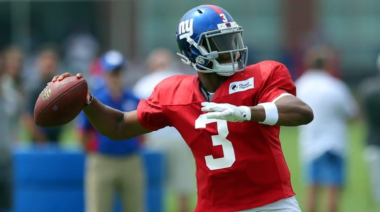 New York Giants' Geno Smith throws a pass during training...