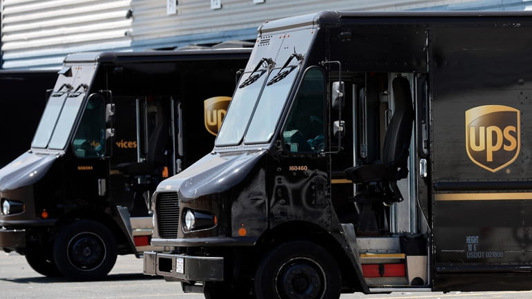 FILE- United Parcel Service trucks are seen parked at a...