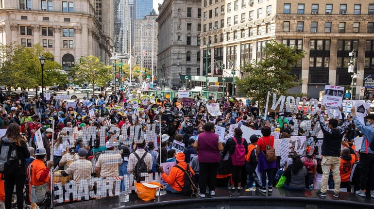 Demonstrators hold signs during an eviction protest in Foley Square...