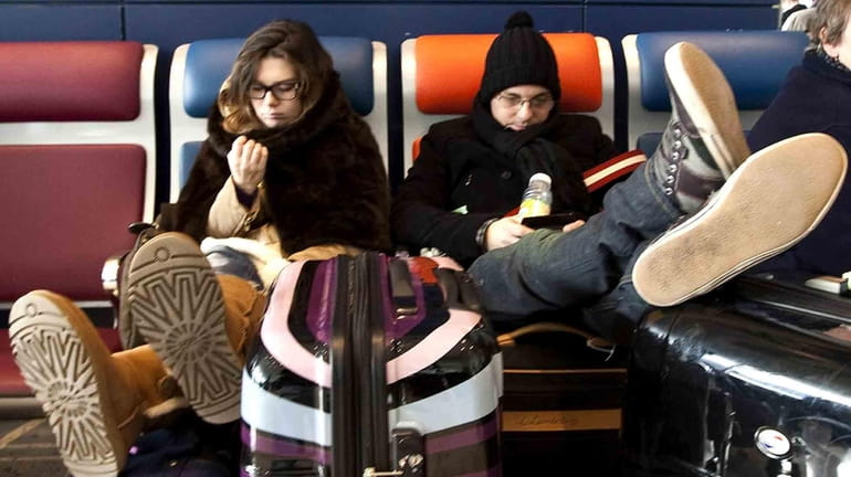 Travelers wait at JFK airport while flights were delayed, Monday....