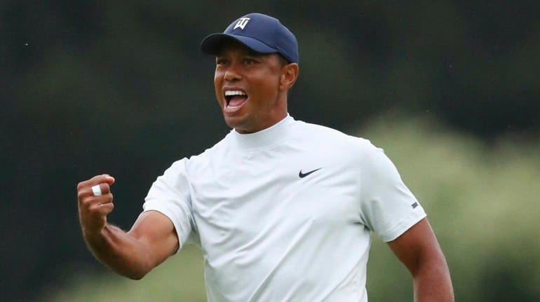 Tiger Woods reacts to his birdie putt on 15 during...