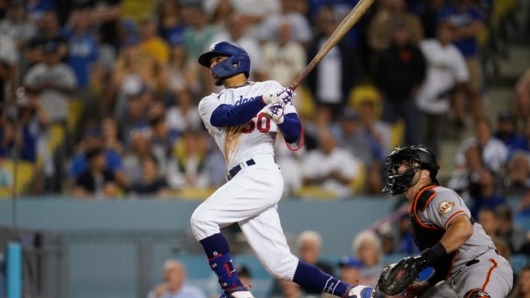 Los Angeles Dodgers' Mookie Betts watches his three-run home run...